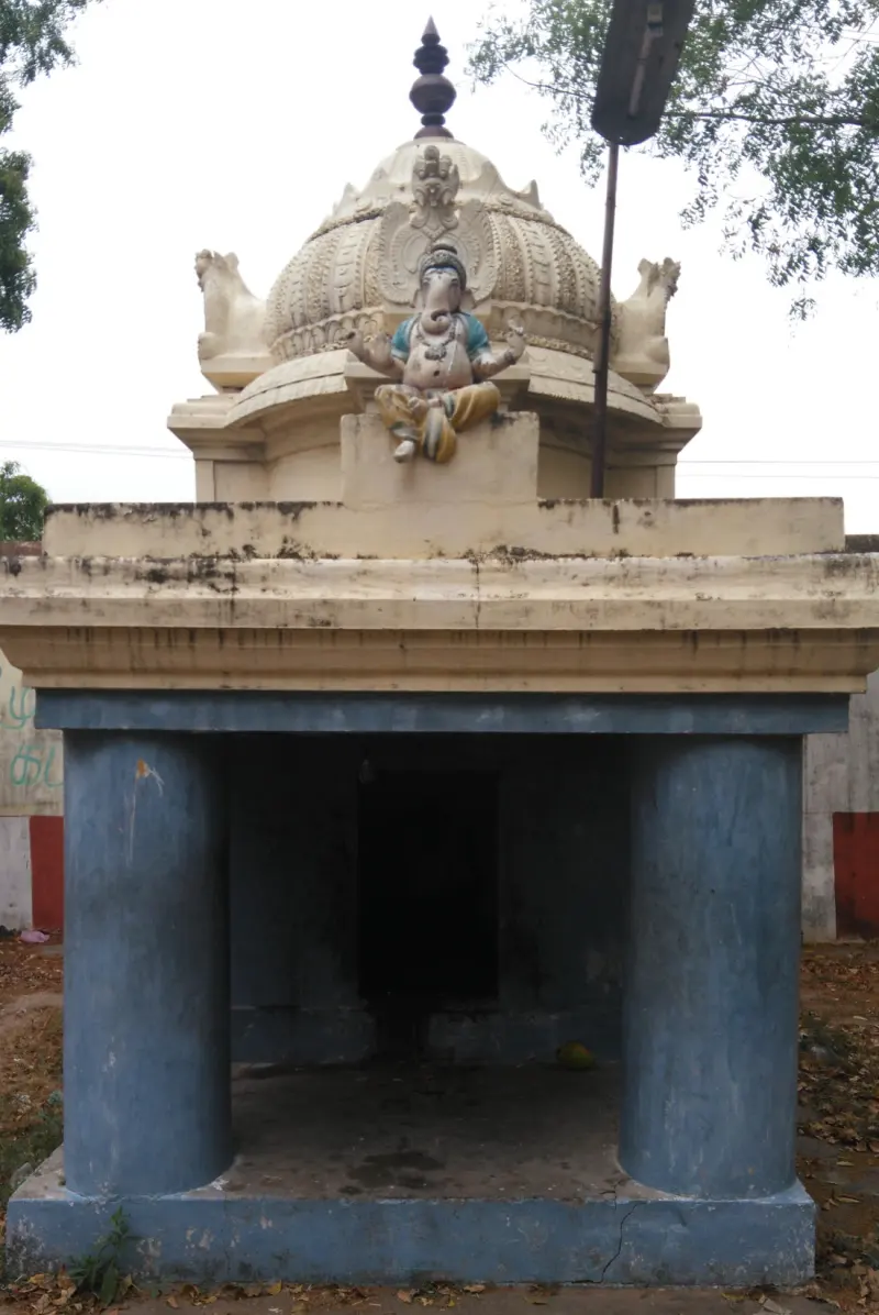 A small blue-pillared shrine with a seated Vinayakar statue on its dome