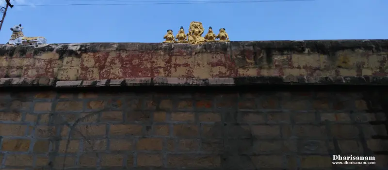 Small golden figures and a lion on the stone wall, with a bull statue at the left