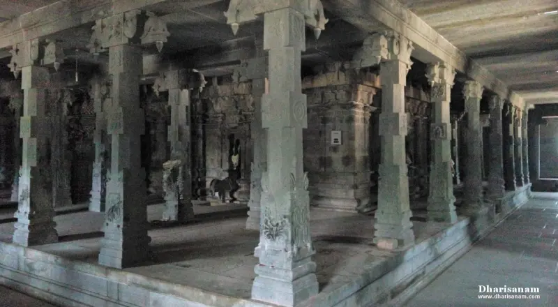 A long hall of square-sectioned granite pillars with carved bases, seen from a corner