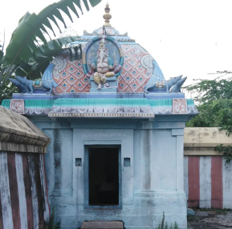 A small pale blue shrine with a seated Vinayakar figure above the doorway.