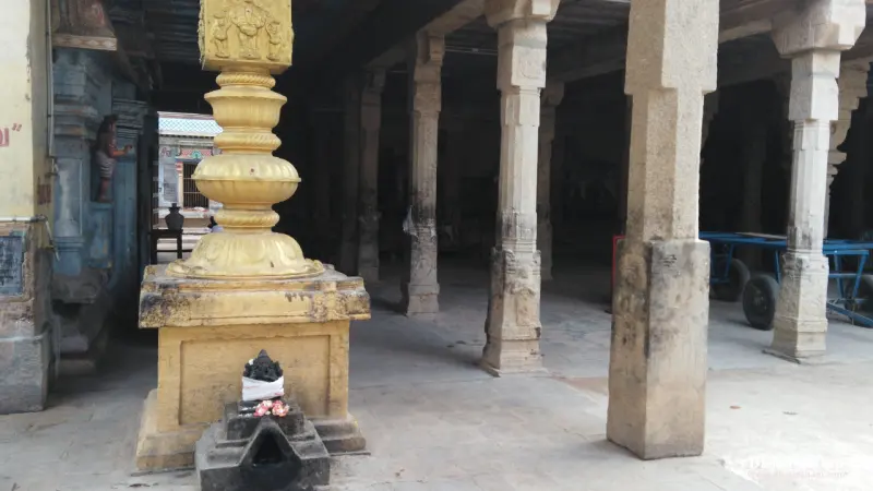 A gold-clad pillar with a small shrine at its foot