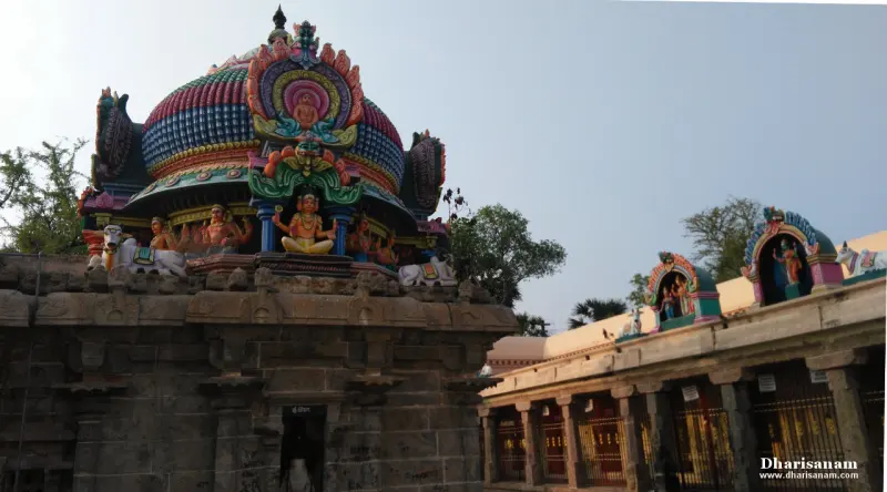 Painted dome tower with deity sculptures above stone walls