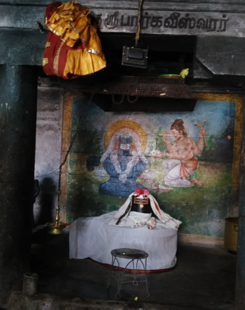A lingam draped in white cloth on a low platform, with a painted scene of a seated lingam and a kneeling man behind.