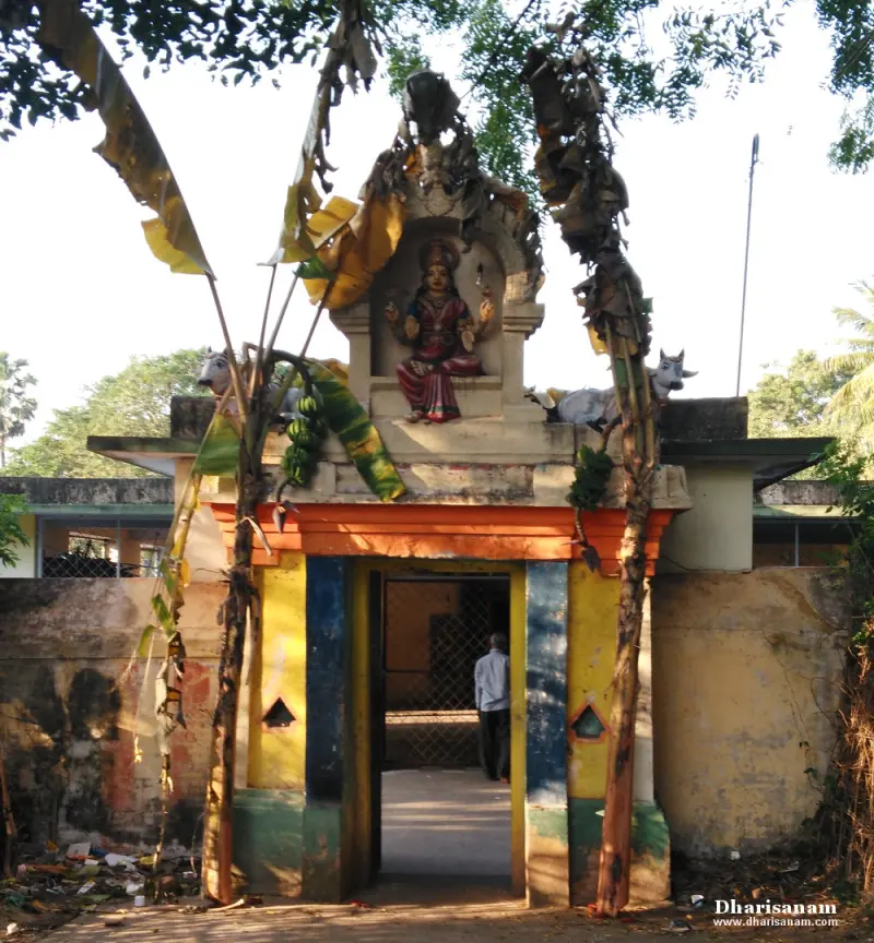 A painted gateway with a seated goddess figure and two bulls above it, framed by banana leaves