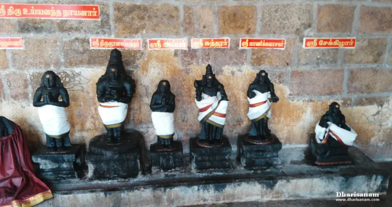Six dark saint idols with white cloths and Tamil name boards