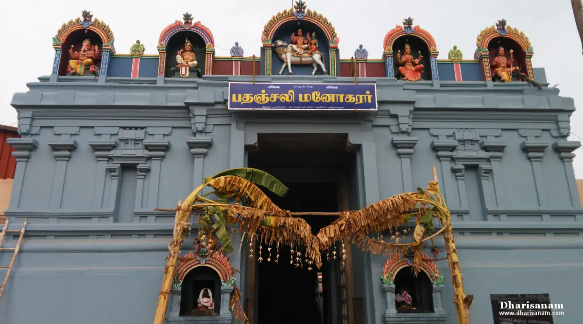 A blue-grey temple front with a Tamil name board and painted figures in five niches above