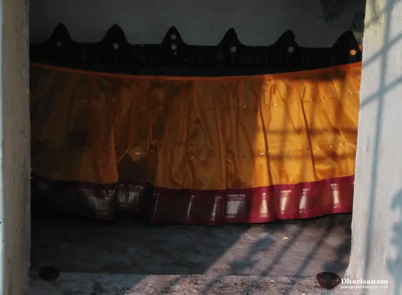 Seven crowned idol tops above an orange curtain in a shrine