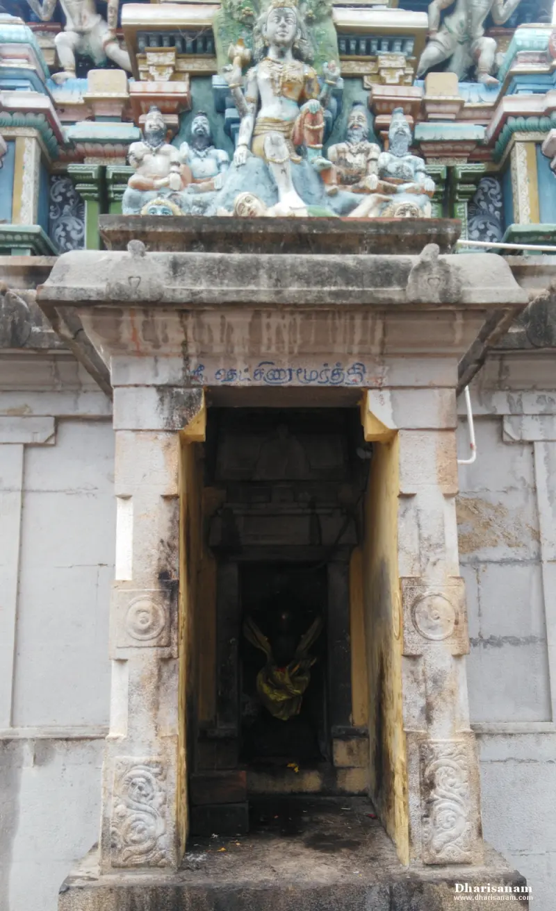 A stone shrine doorway with a Tamil name board below a group of painted sculptures.