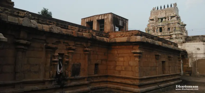 A long wall of brown stone with carved bands, a small upper room and a tower at right