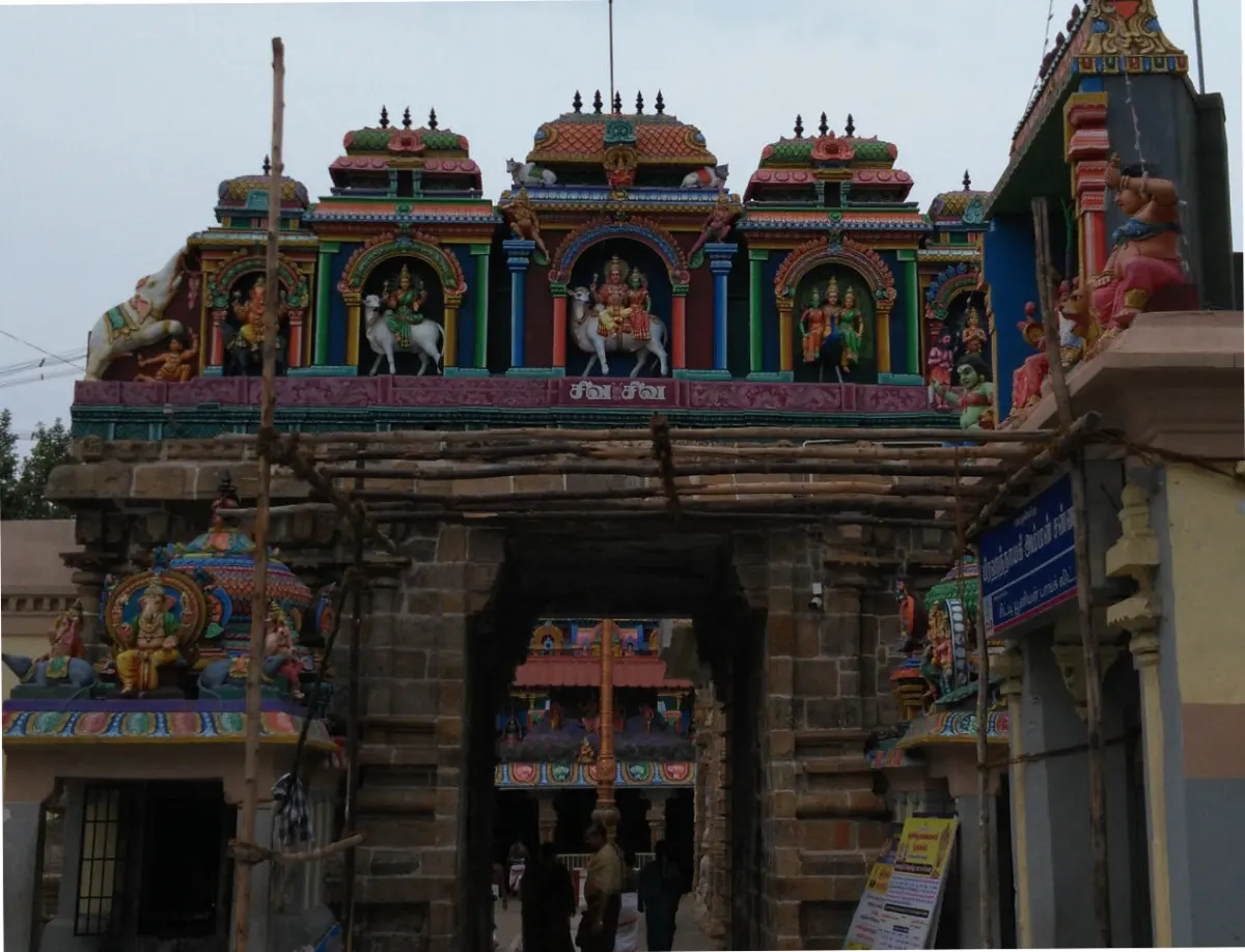 Stone archway entrance with colourful gods and Nandi statues on top