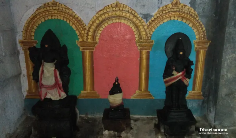 Three idols under painted golden arches, with green, pink and blue backgrounds, the middle one small