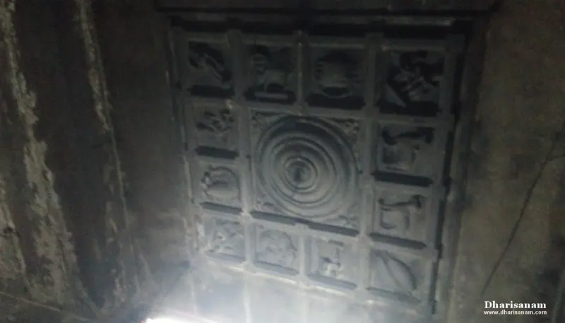 Carved square panels around a central circle on a dark ceiling