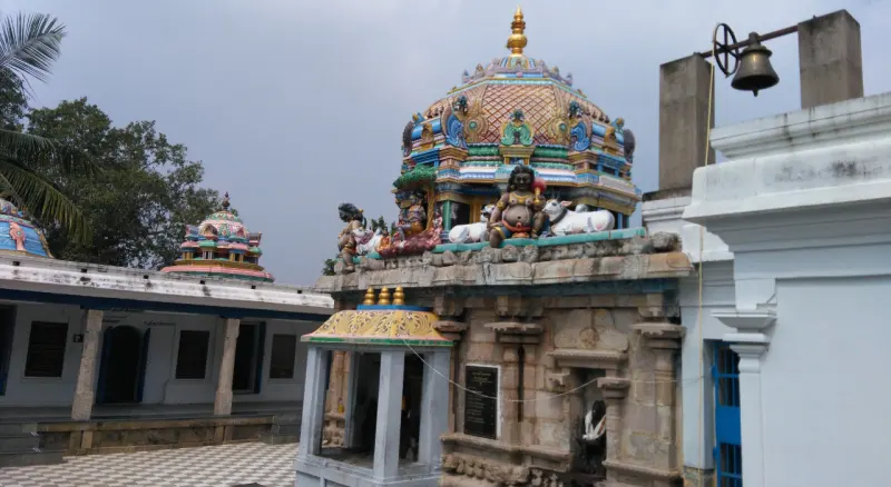 Colourful tower with deity figures above a stone sanctum