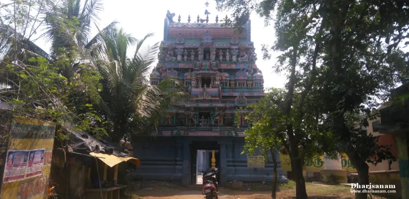 A colourful tower over the temple entrance among trees