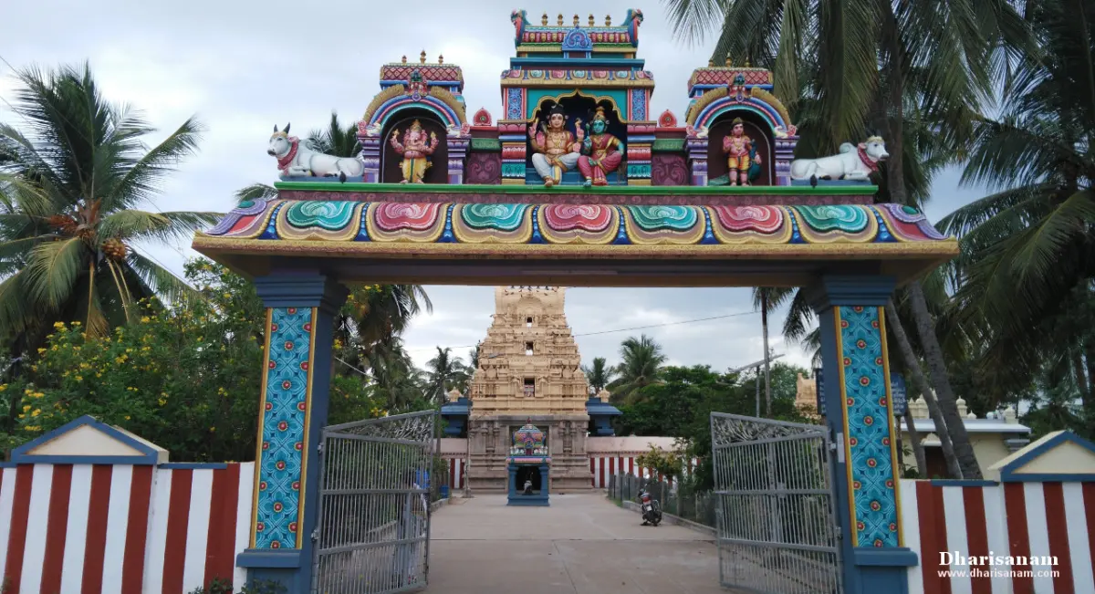A painted arch over the entrance with a bull on each side and figures at the centre; a tower stands beyond