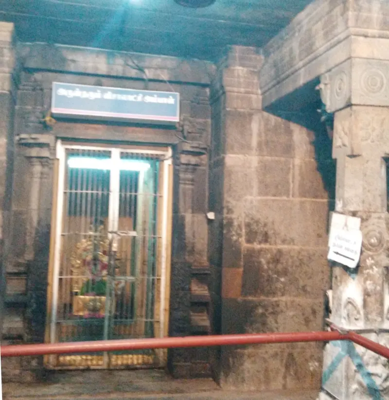 Dark gated shrine with a lamp glowing inside