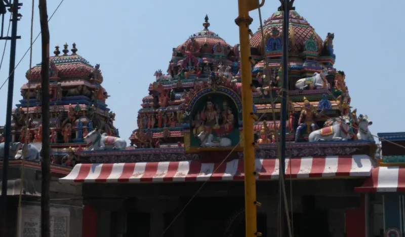 Towers with painted figures rise above a shrine whose front is striped red and white.