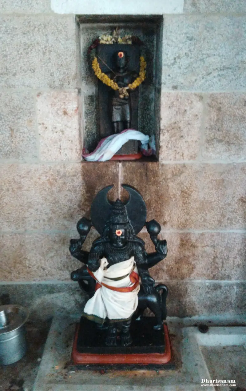 A small garlanded image in a wall niche above a four-armed seated image with a dark halo