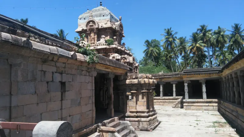 The granite sanctum tower rising behind the corridor wall, with a pillared corridor on the right