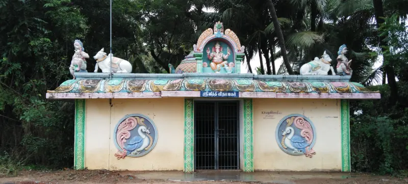 A small shrine with a Ganesha figure over the doorway, bulls on the roof, and swan roundels on the front wall.