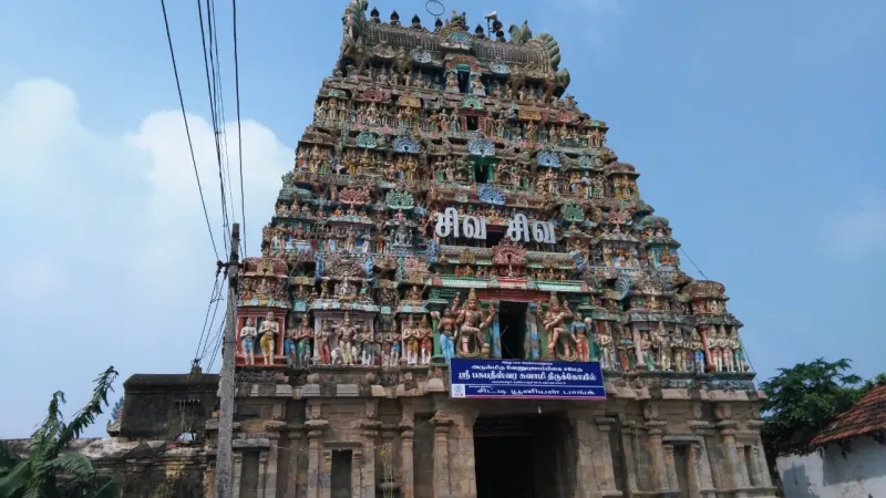 Tall sculpted tower covered in painted figures under a blue sky