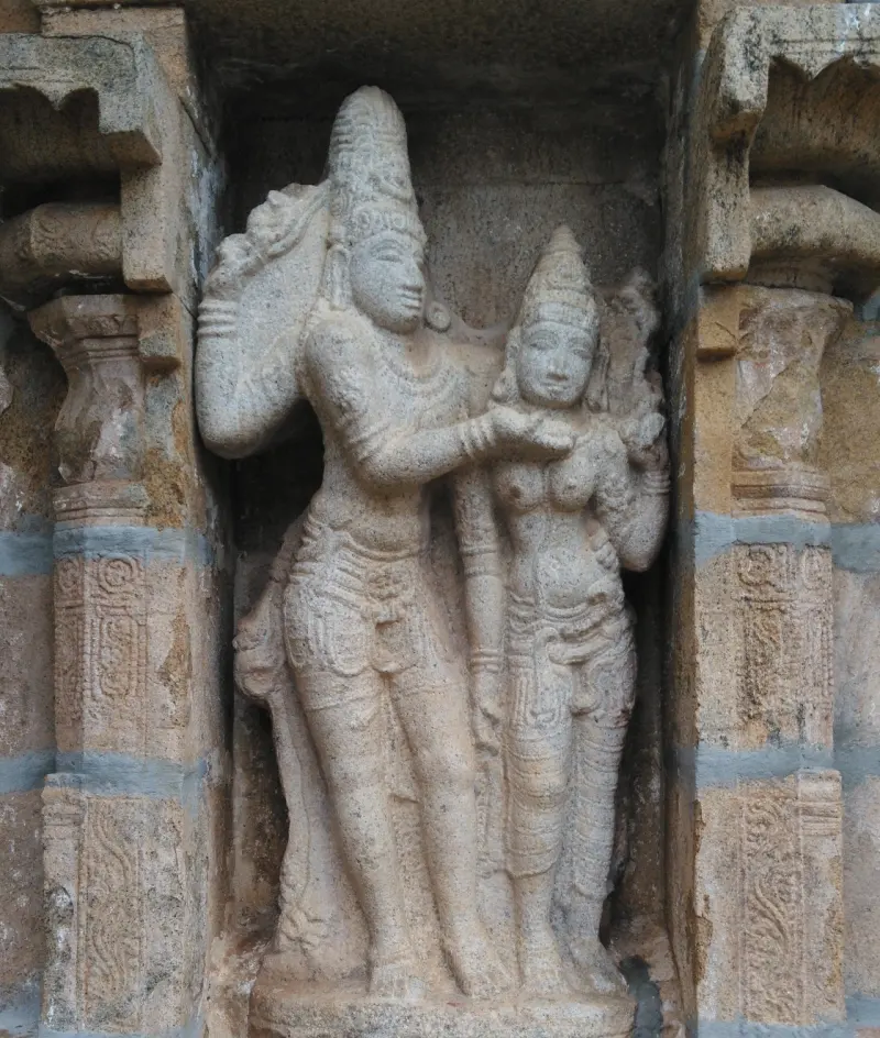 Carved stone figures of a man and a woman standing close together in a wall niche