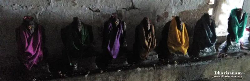 Seven small idols in a row covered with purple, green and yellow cloths
