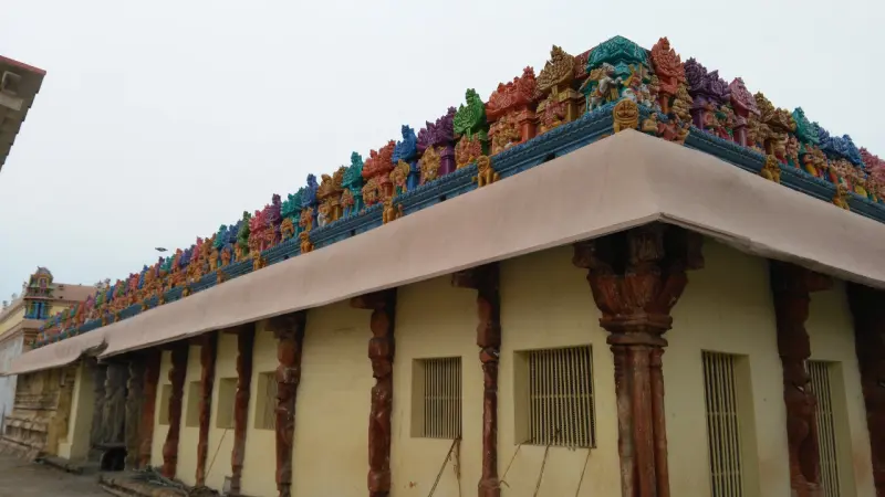 Row of colourful deity figures on a yellow wall