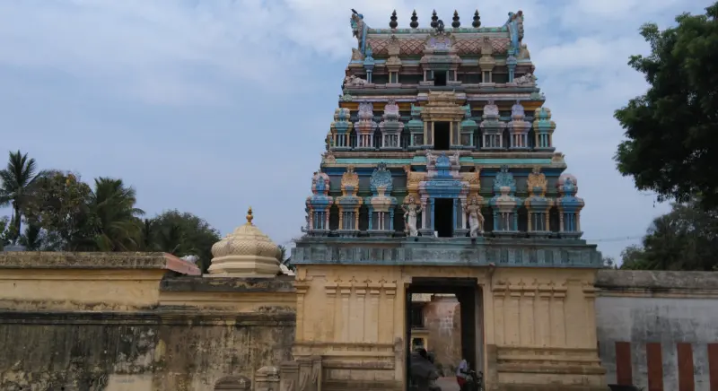 The Rajagopuram, a colourful tower, rising above the entrance wall against a blue sky