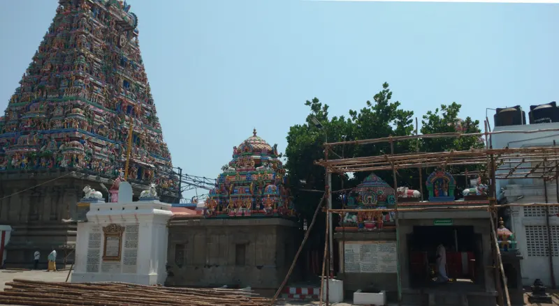 The tall tower at the left, with a smaller dome and a scaffolded shrine in the courtyard beside it.