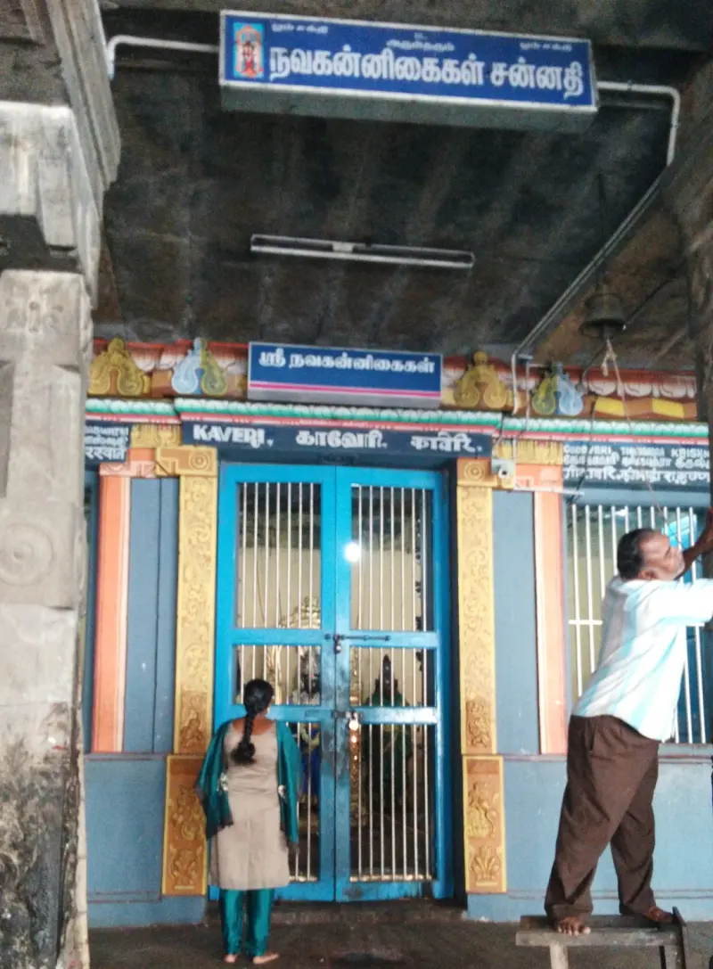 Blue shrine doors with name boards and two worshippers