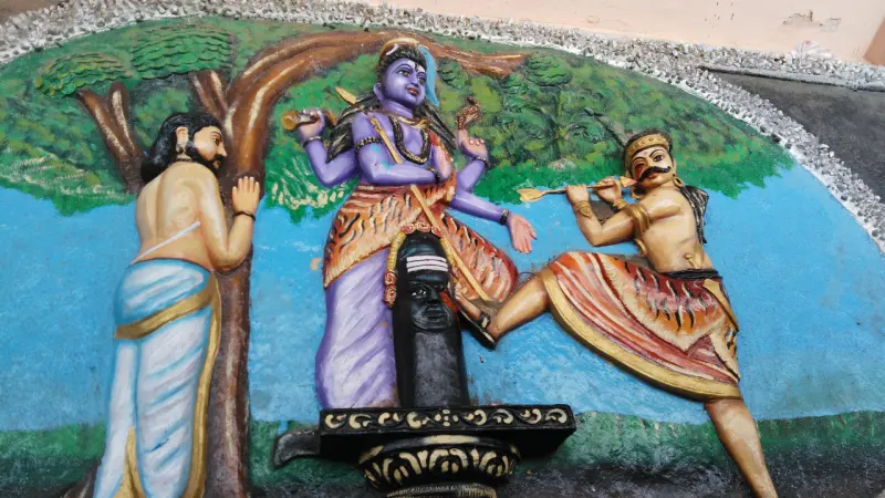 A painted relief of a hunter raising a foot to a lingam, blue-skinned Shiva behind it and a man at left.