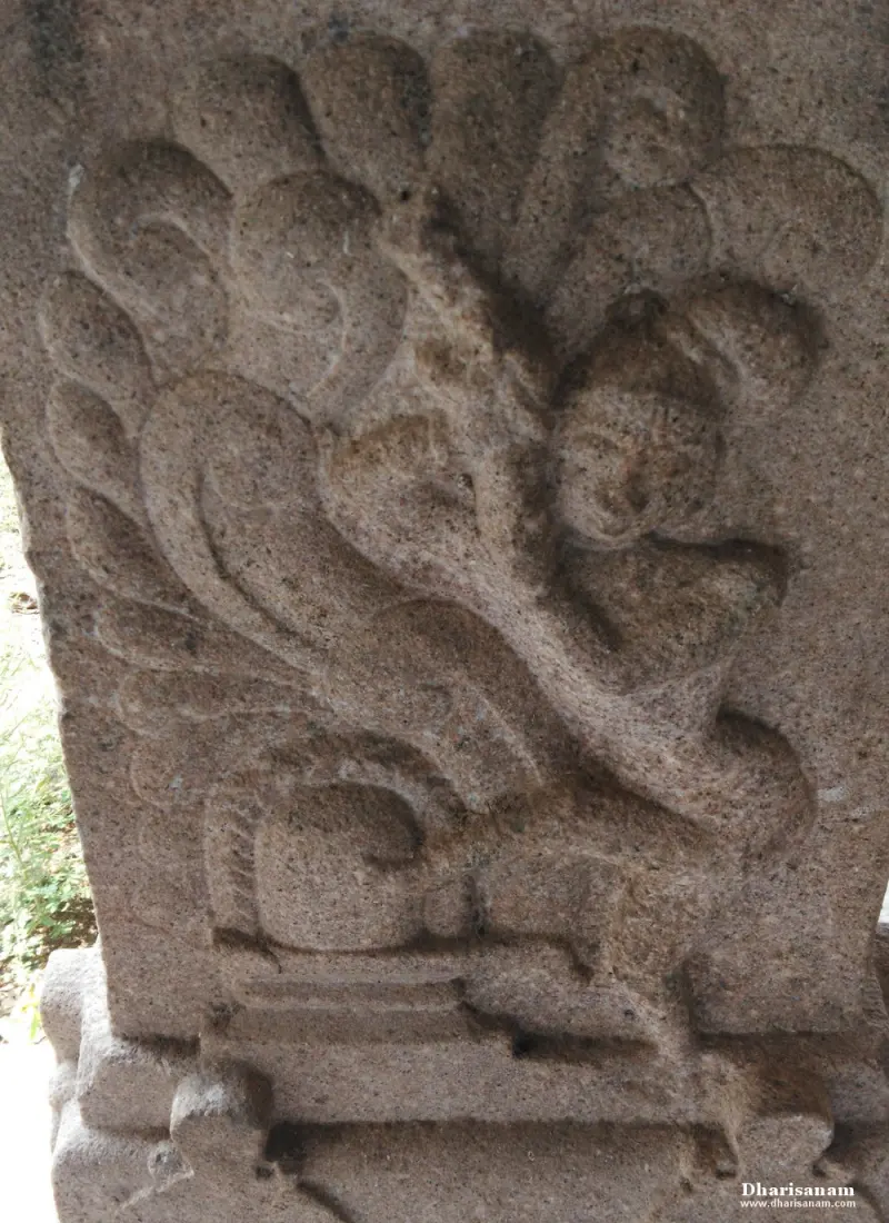 Pillar relief of a lingam with scrollwork and a small face above it