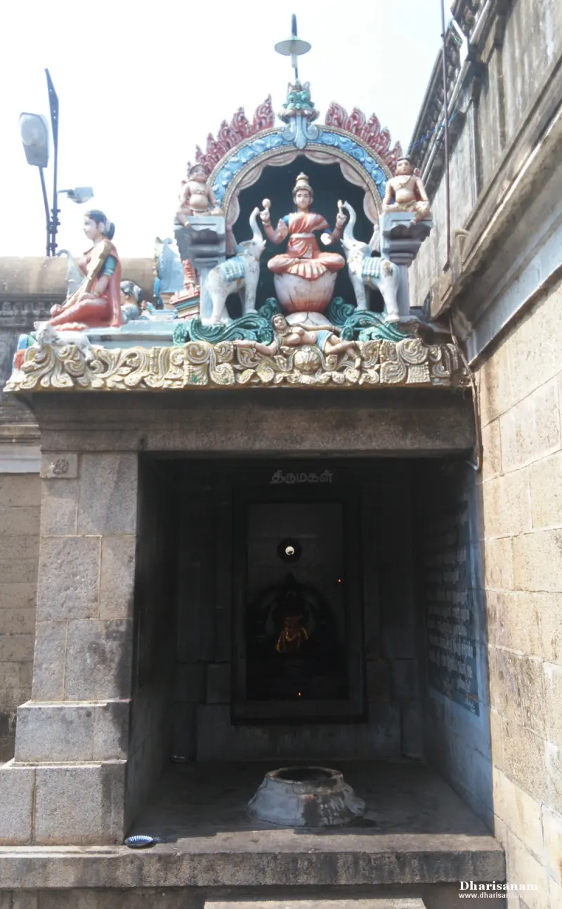 A small stone shrine topped by a painted figure of Lakshmi between two elephants, the Tamil word Thirumagal inside