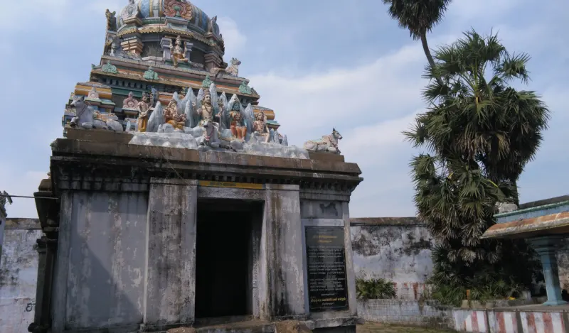 Small tower with deity sculptures rising over a shrine doorway