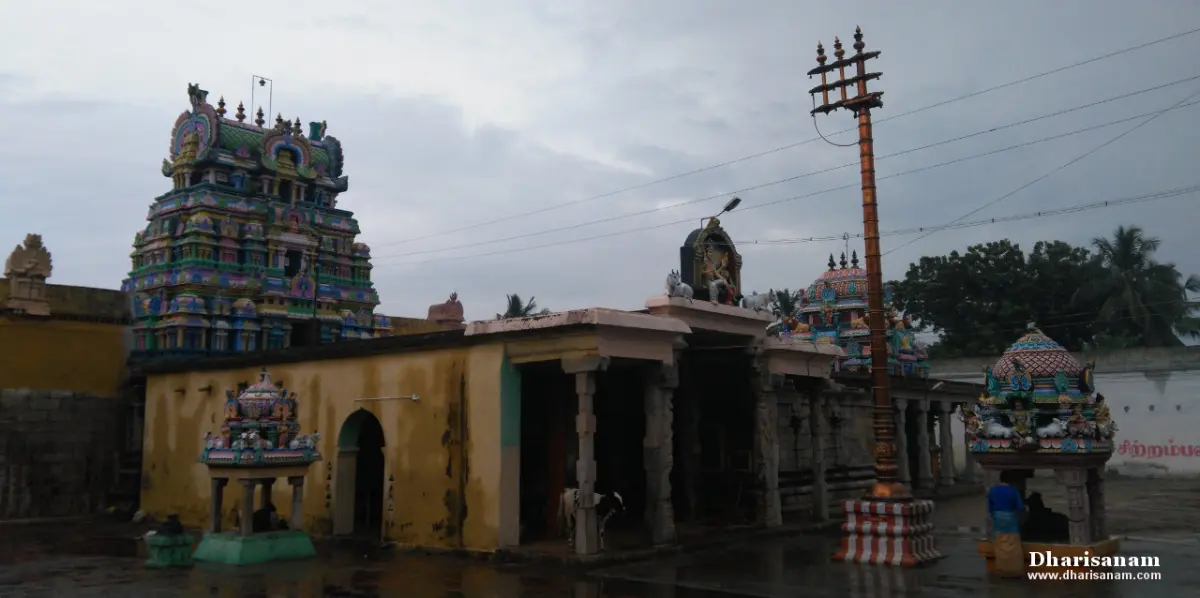 Painted tower, a flagstaff and small shrine roofs seen over a yellow outer wall on a rainy day