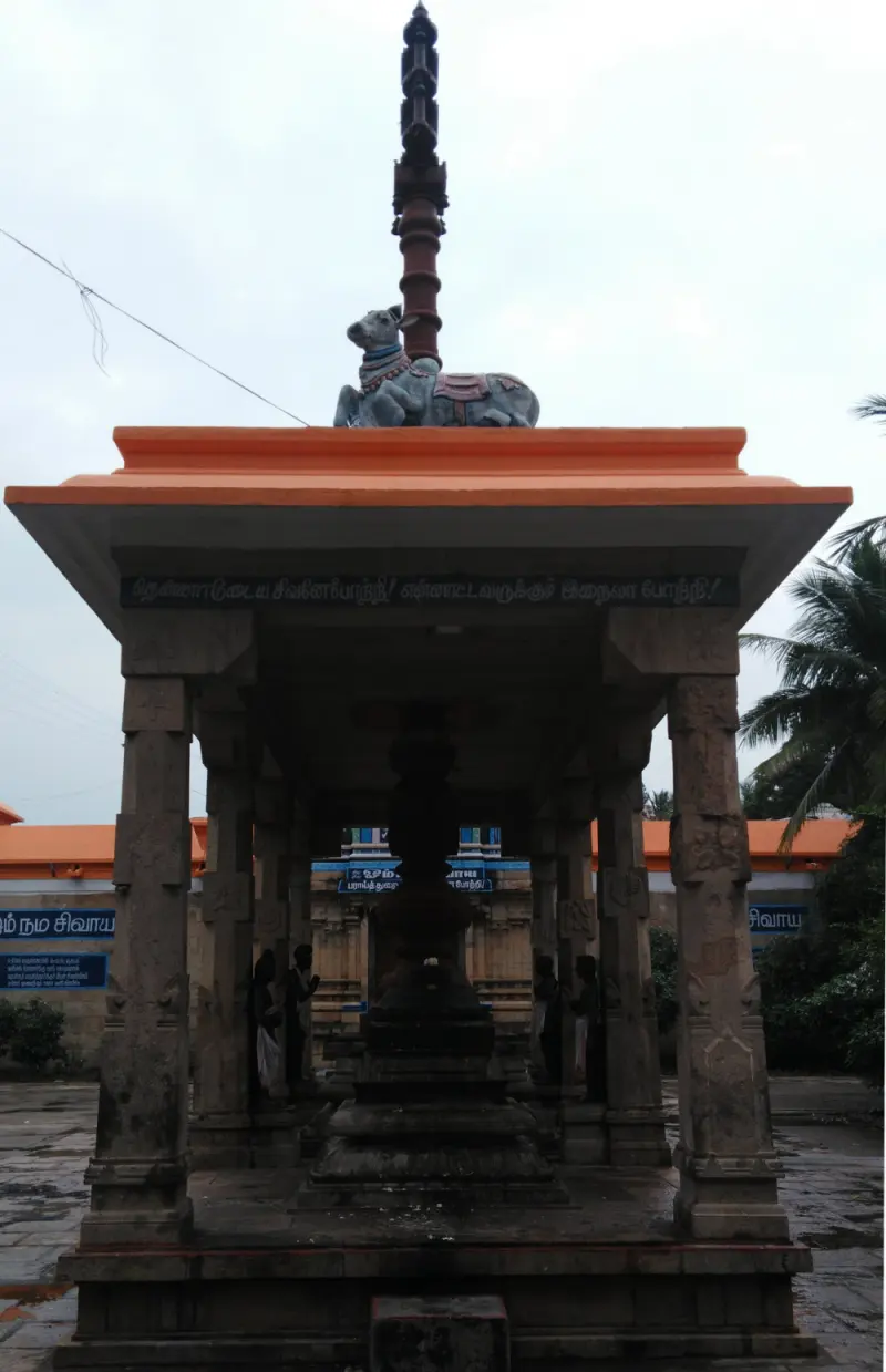 A pillared pavilion with a Nandhi on top and a tall pillar behind