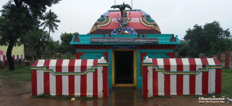 Shrine with a painted dome and a red and white striped front wall, and a Tamil name board