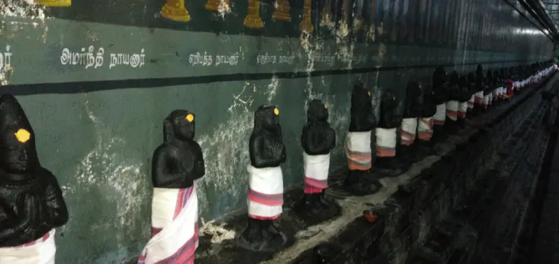 Long row of draped idols with name labels above