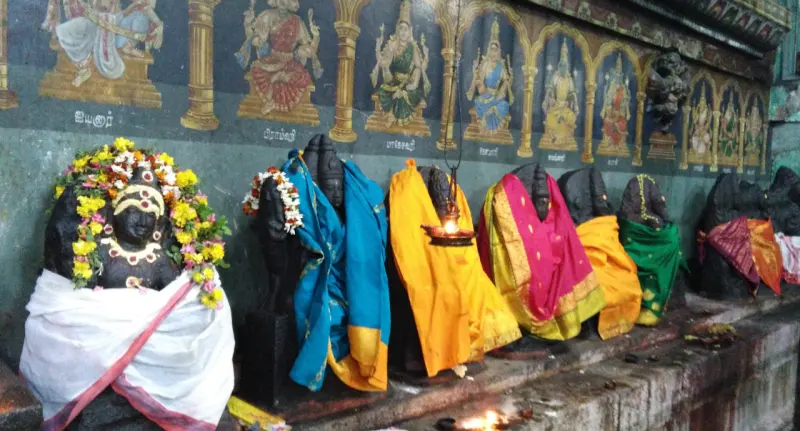 Row of draped goddess idols under painted panels