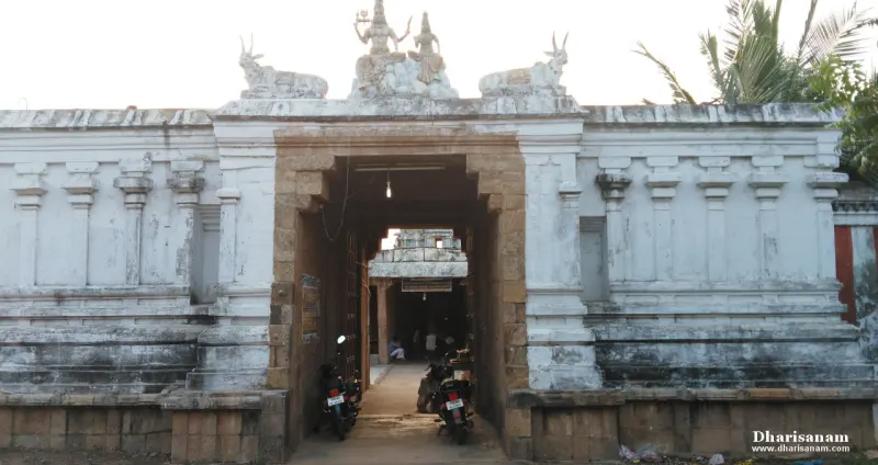 A whitewashed gateway with a flat top and a bull on each side of a seated divine pair, leading to a hall