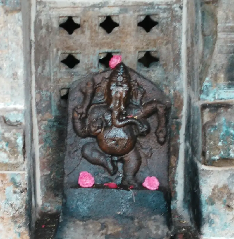 Dark stone dancing elephant god with pink flowers