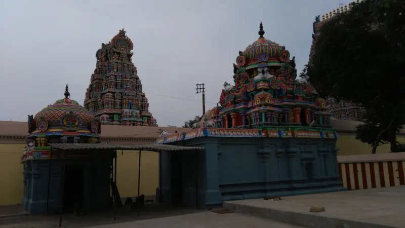 Blue shrines with colourful tops under a tall gopuram