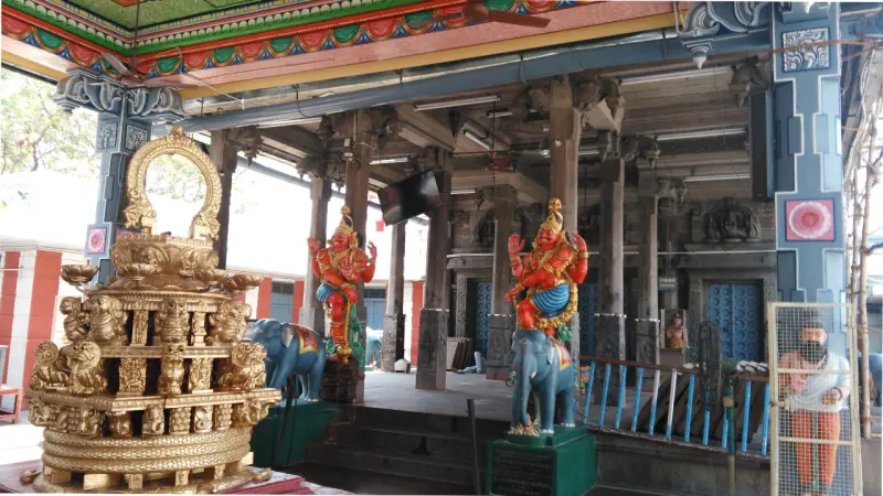 Two painted standing figures with their mounts inside a hall, and a gilded ornament in the foreground.