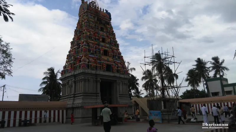 A tall tower covered in painted figures, seen from the courtyard with scaffolding beside it