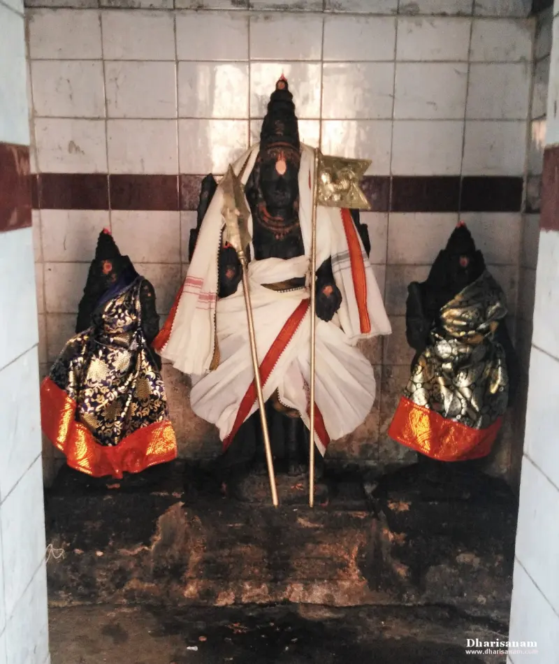 A central idol holding a spear and flag, flanked by two smaller idols in brocade.