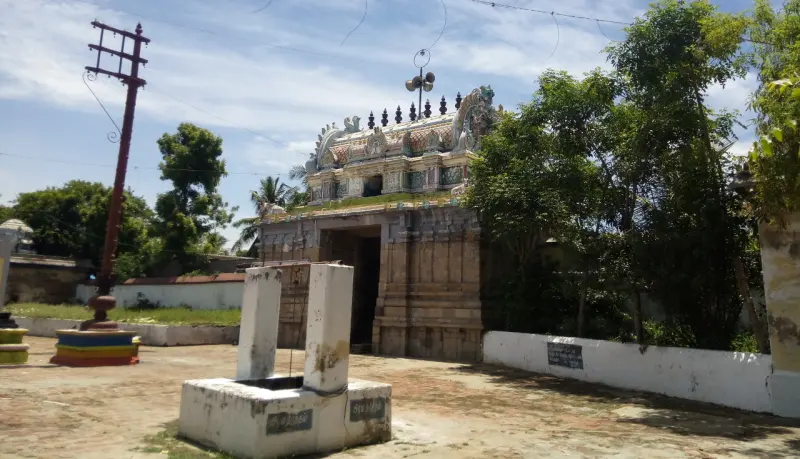 Stone platform in the foreground, with the temple tower and a tall flagstaff behind it