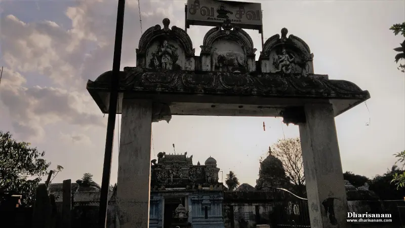 A stone arch with three sculpted panels, the temple towers seen beyond it.