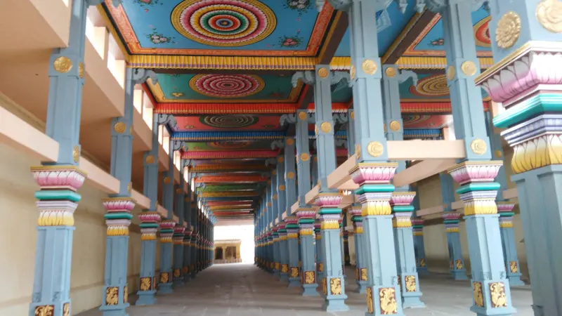 Rows of blue pillars with painted capitals and a ceiling in colourful circular patterns.