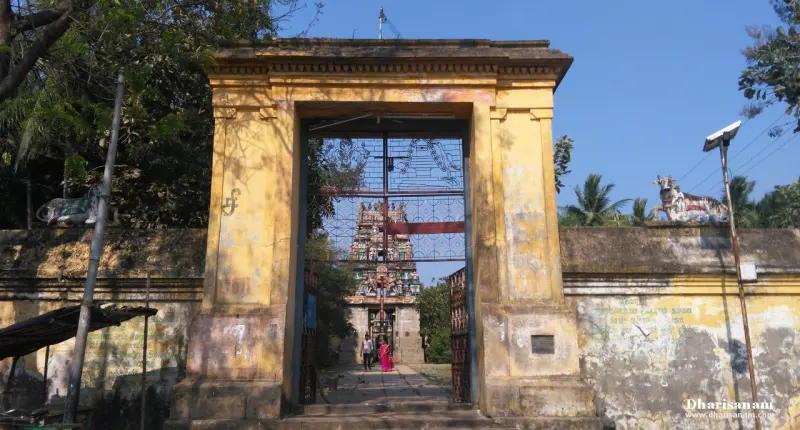 A yellow gateway with bull statues, tower seen through it